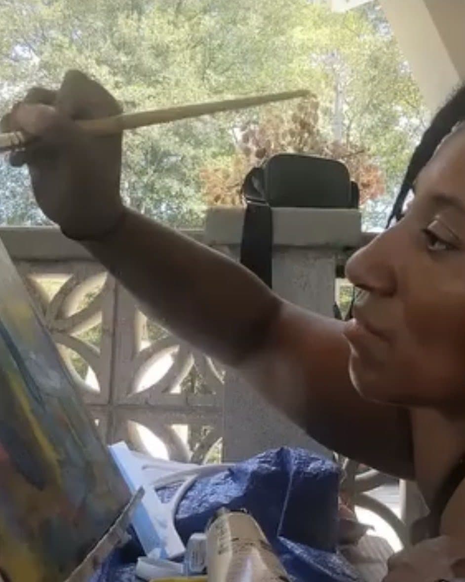Sharese Favor at work on a painting on a sunny porch